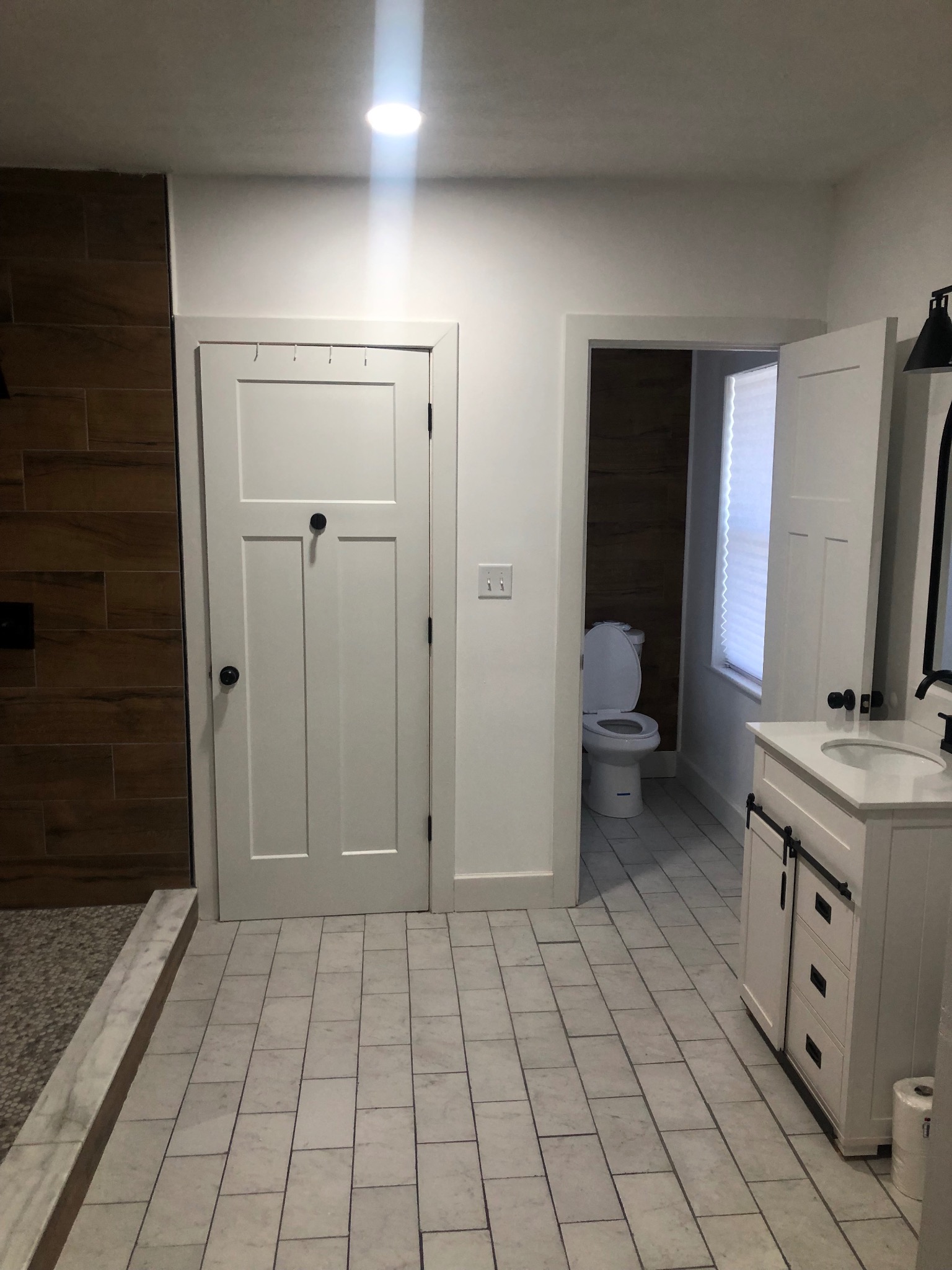 Completed bathroom renovation with tile flooring and white vanity
